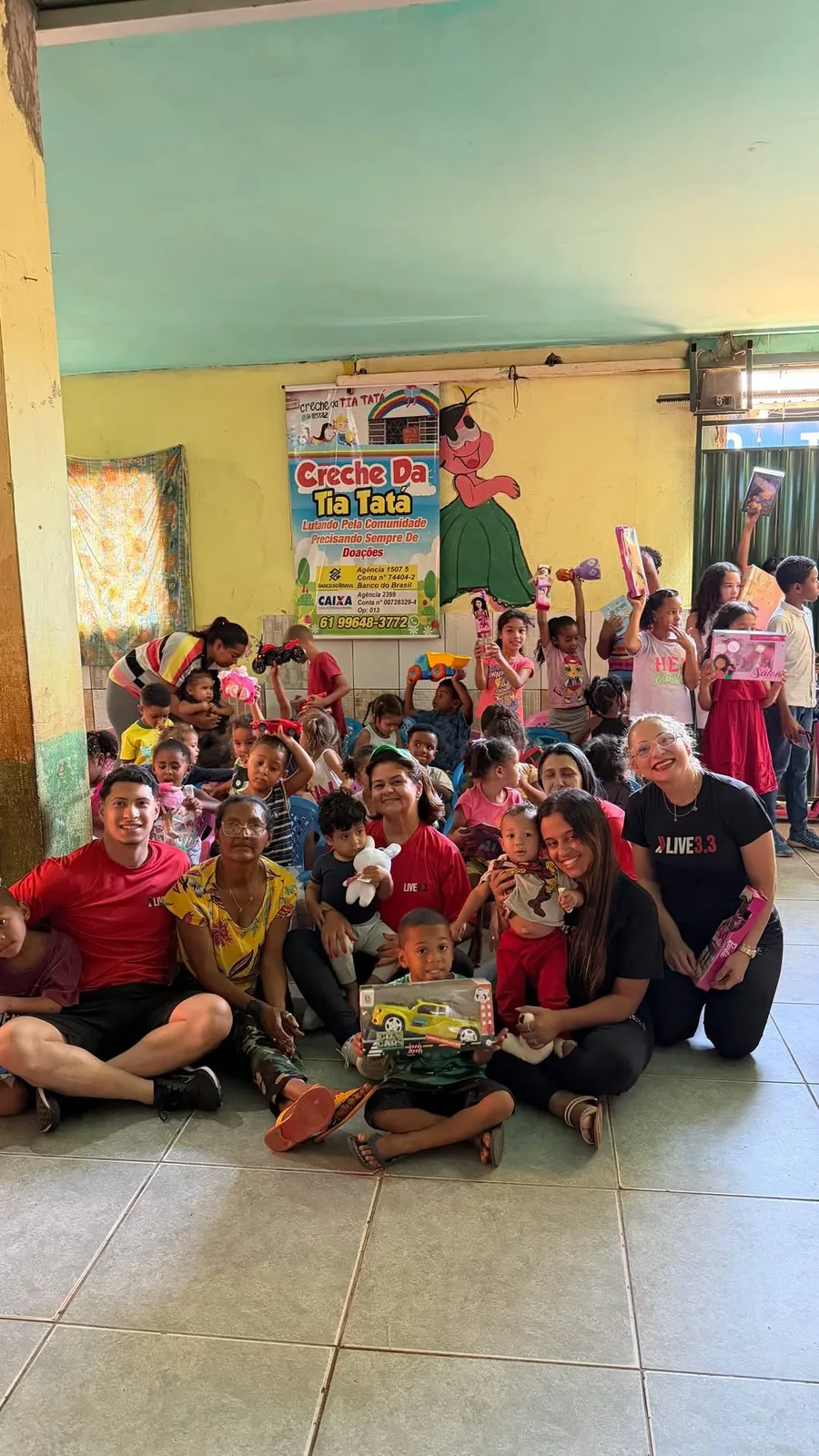 Equipe da Live 3.3 com crianças de uma creche durante a entrega de brinquedos